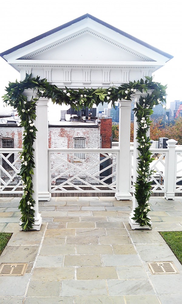Ceremony arch at Halcyon House with greenery garland and flowers by Elegance and Simplicity, Inc.