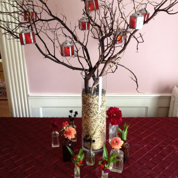 Escort card table arrangement with antique bottles and birdseed